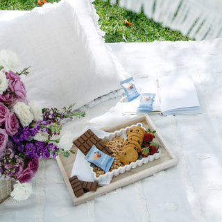 Sneaky Wholefoods Peanut Butter Cookie Nourish Bites spread out on a picnic rug with other food, showcasing a healthy, high-protein, gluten-free snack option for outdoor gatherings