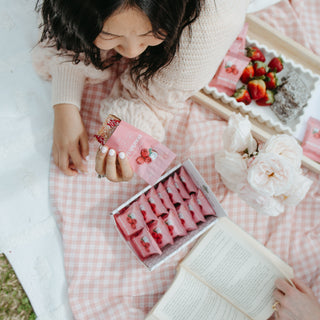 Lady enjoying a Sneaky Wholefoods Raspberry Lamington Nourish Bite, revealing its two-layer texture made from wholefoods, combining gluten-free ingredients for a nutrient-packed, dessert-inspired snack