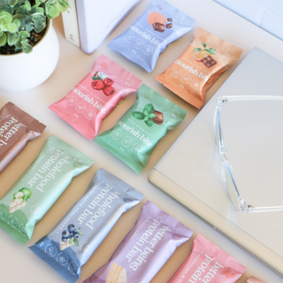 A vibrant assortment of Sneaky Wholefoods Protein Bars and Nourish Bites from the Monthly Snack Bundle, ready to grab and enjoy for a month of nourishing snacking on-the-go, promoting an active lifestyle and everyday well-being