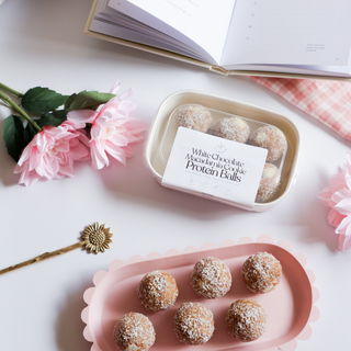 Protein Balls in Packaging: A neatly sealed packet of white chocolate macadamia protein balls, featuring vibrant branding and a transparent window revealing the snacks inside.